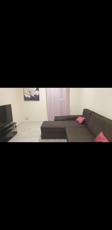 un salon avec un canapé et une télévision dans l'établissement Appartement chaleureux au pied du tramway et à 10 mn de Valenciennes., à Denain