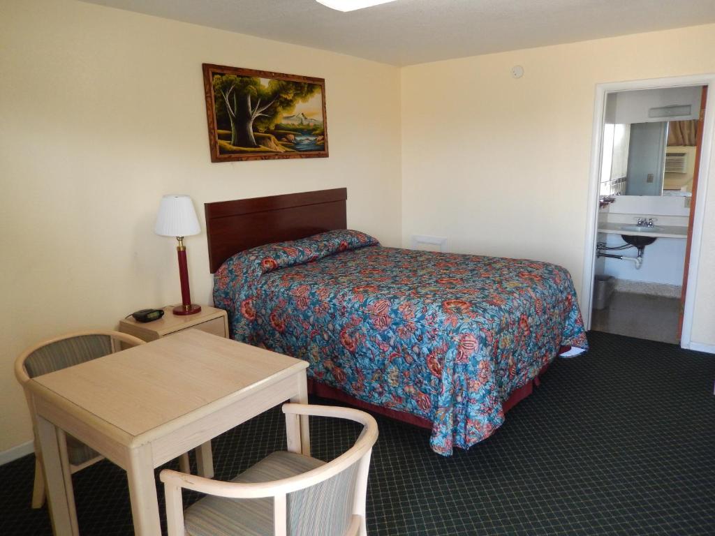 Boise CityにあるTownsman Motelのベッドとテーブルが備わるホテルルームです。