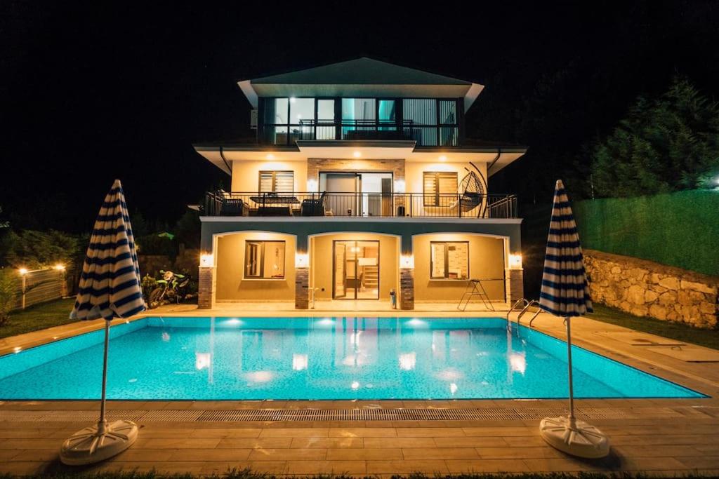 a large house with a swimming pool at night at FULL MÜSTAKİL GÖL MANZARALI HAVUZLU VİLLA- BTK01 in Sapanca