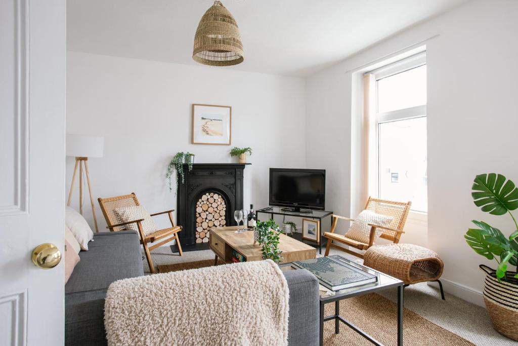 a living room with a couch and a fireplace at Cosy period cottage 2min walk to the beach in Portrush