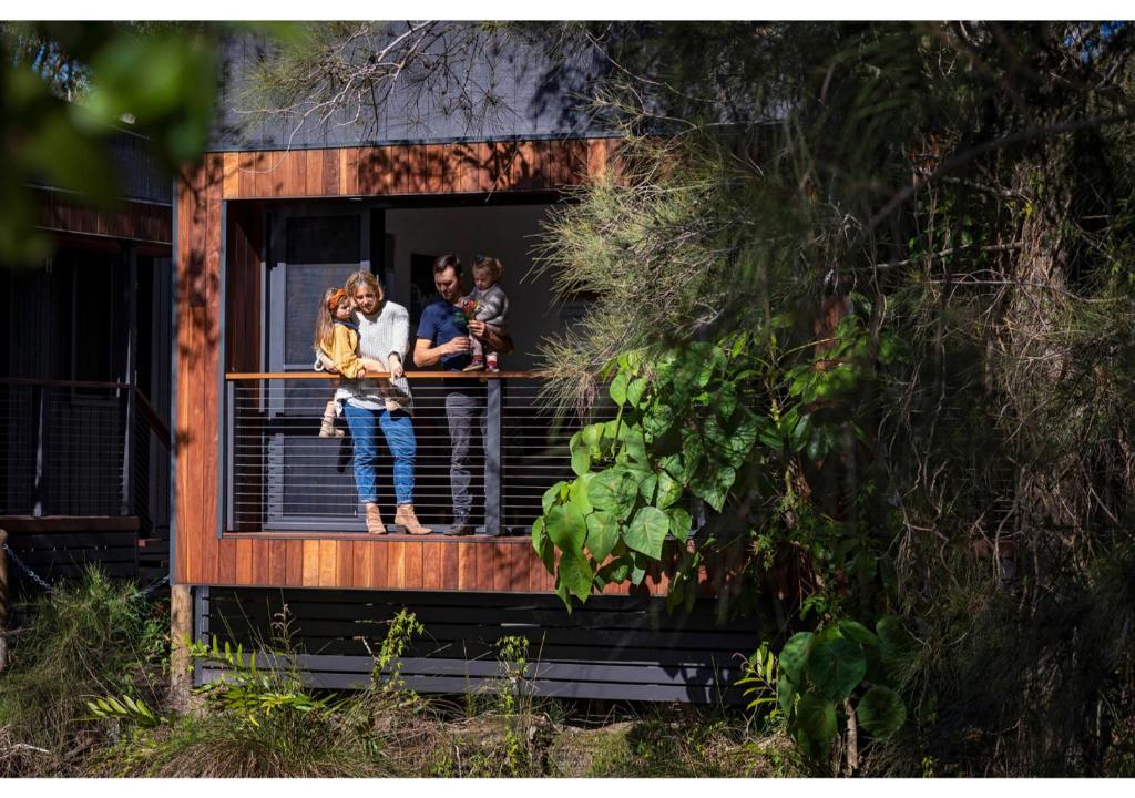 a group of people standing on a balcony of a house at Discovery Parks - Byron Bay in Byron Bay