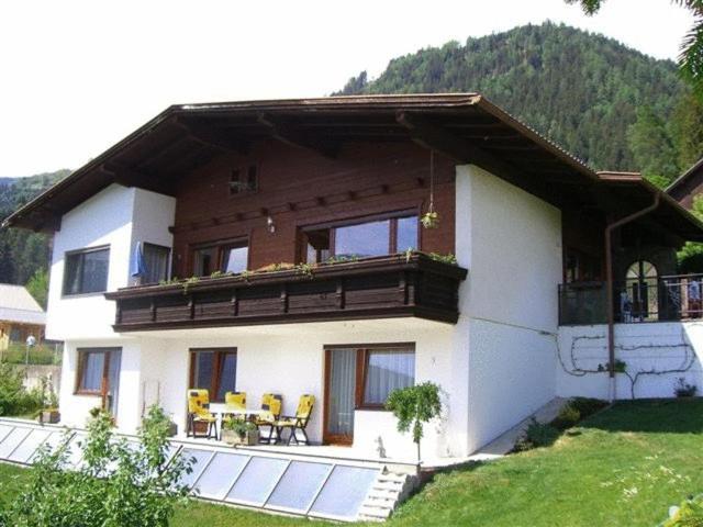 ein Haus mit einem Balkon, einem Tisch und Stühlen in der Unterkunft Ferienwohnung Jeller in Lienz