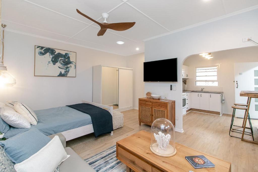 ein Schlafzimmer mit einem Bett und ein Wohnzimmer in der Unterkunft Snapper Rocks Studio Number 10 - Wi-Fi Included in Tweed Heads