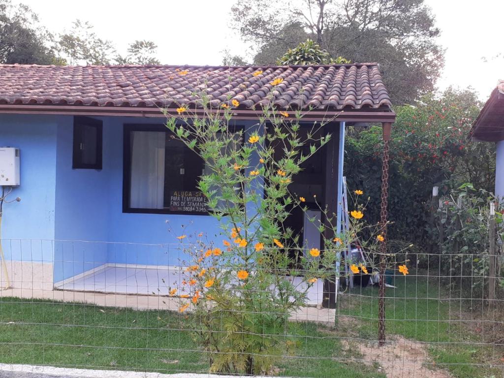 una casa azul con un ramo de flores en el patio en Casa Vênus en São Pedro da Serra