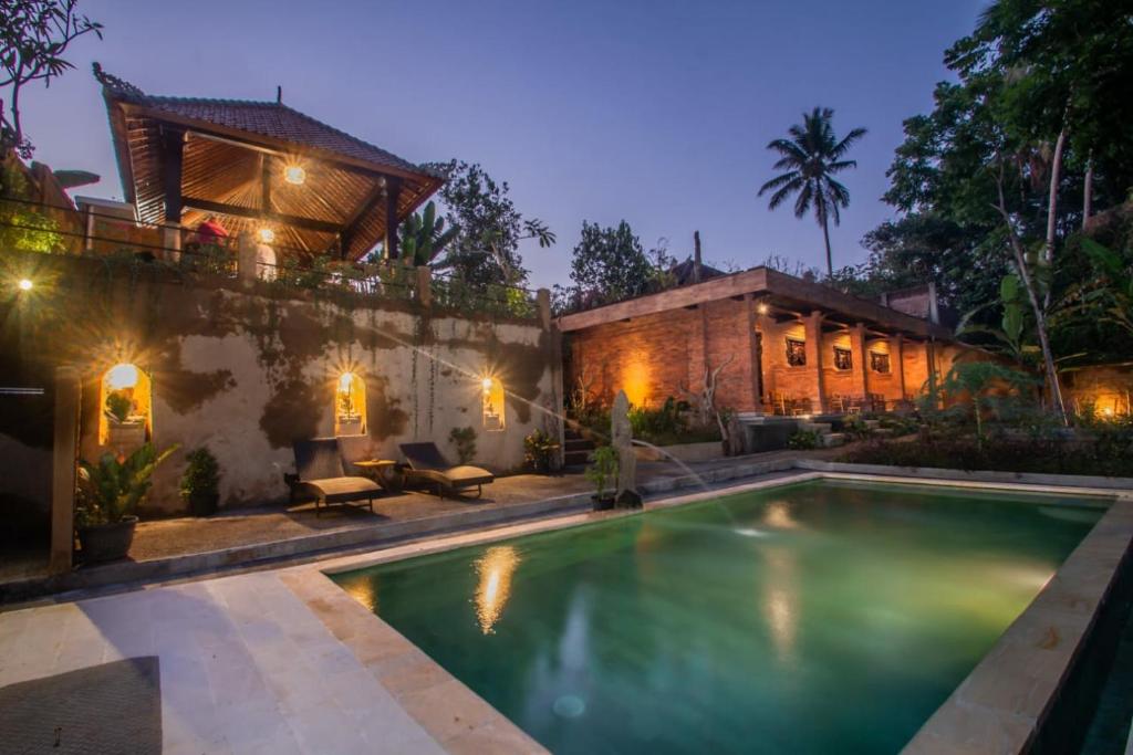 een zwembad voor een huis bij Sanga Suites in Ubud