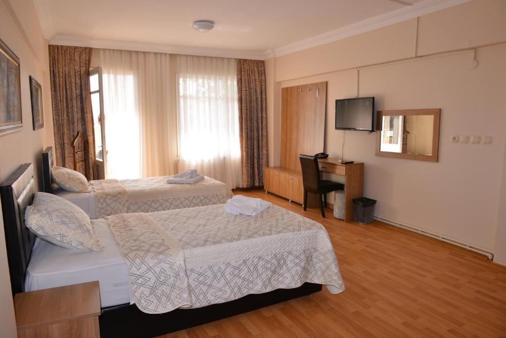 a hotel room with two beds and a television at Emsa Otel Maltepedeki Eviniz in Istanbul