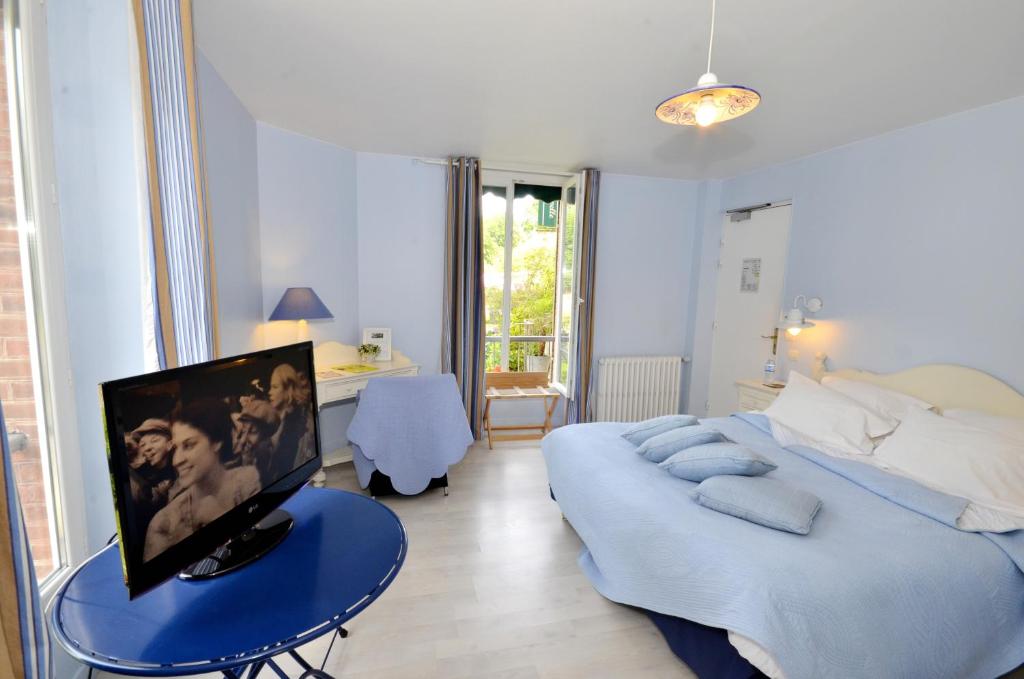a bedroom with a bed and a tv on a table at Logis Hôtel De La Chapelle in Milon-la-Chapelle