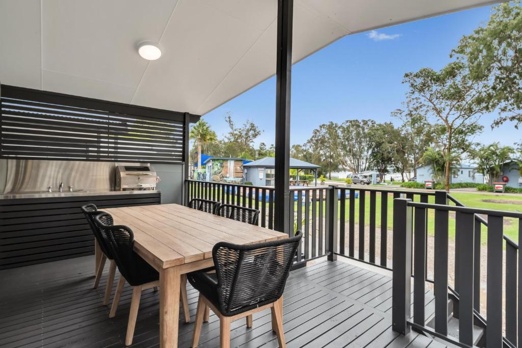 una terraza al aire libre con mesa de madera y sillas en Ingenia Holidays Lake Macquarie, en Mannering Park