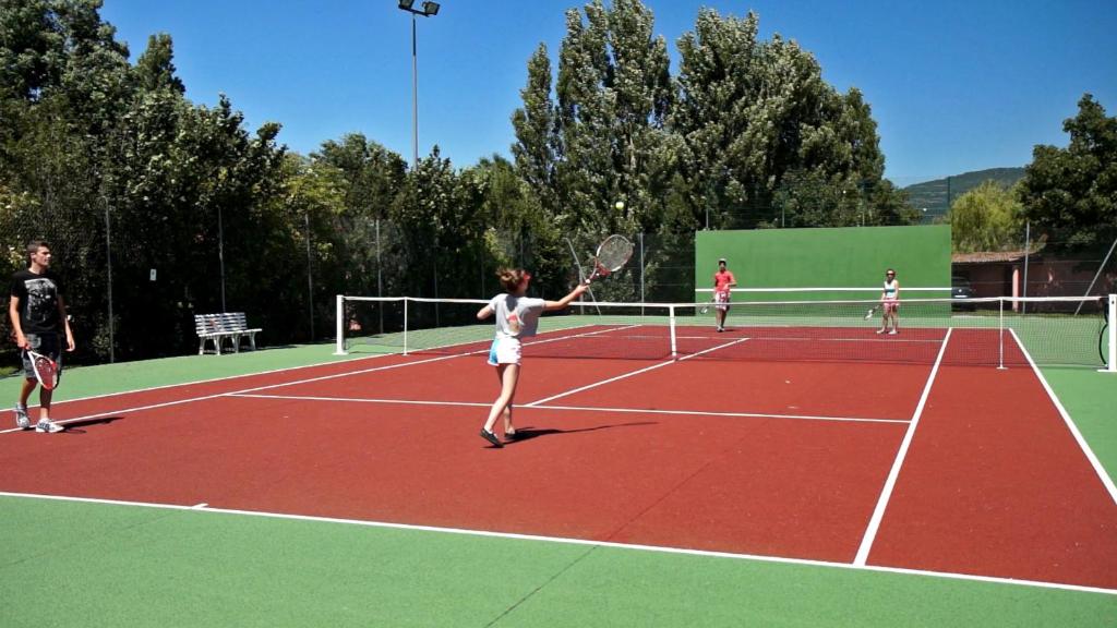 a group of people playing tennis on a tennis court at Le Hameau des Genets in Montlaur