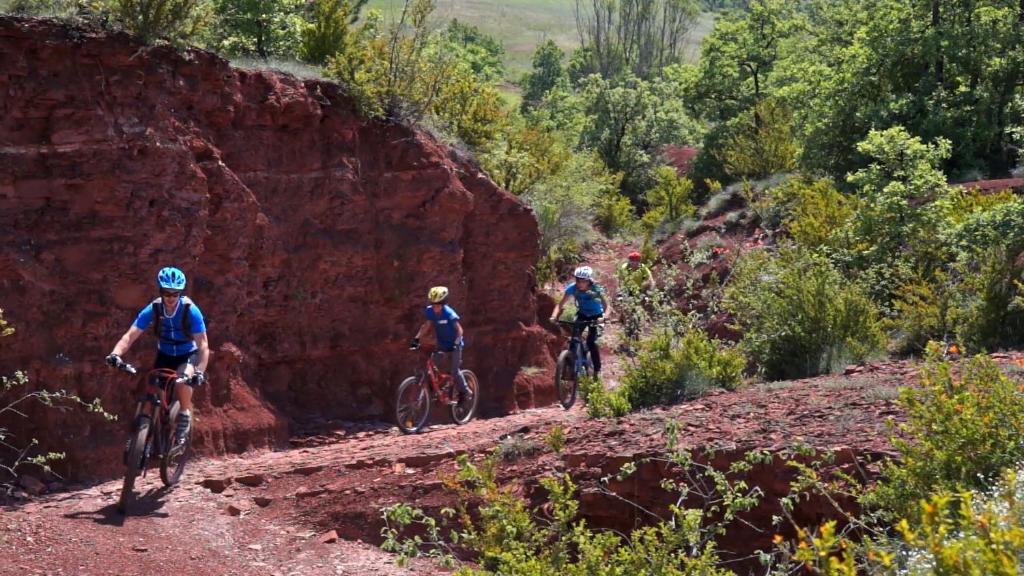 three people riding bikes down a dirt trail at Le Hameau des Genets in Montlaur