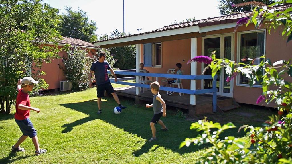 a group of children playing with a soccer ball in a yard at Le Hameau des Genets in Montlaur