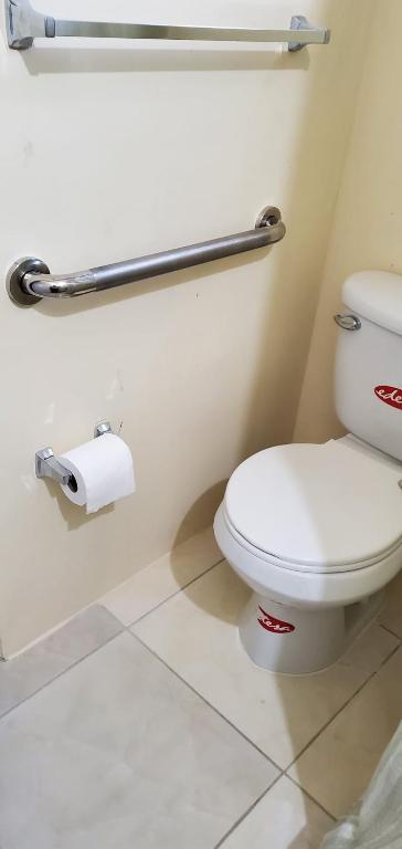a bathroom with a toilet and a roll of toilet paper at Hillside Sunrise, 2 Bed 2 Bath in Gated Community, close to beach, food, clubs & shopping Free Parking, Free Wi-Fi in Montego Bay