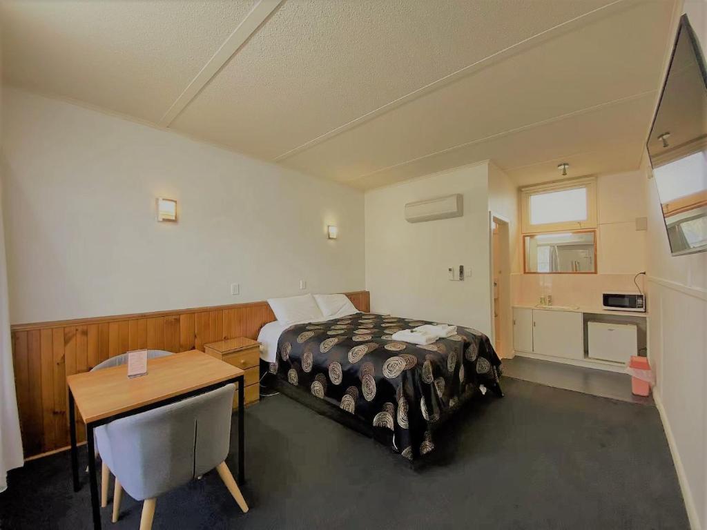 Schlafzimmer mit einem Bett, einem Schreibtisch und einem Tisch in der Unterkunft The Terang Motor Inn in Terang