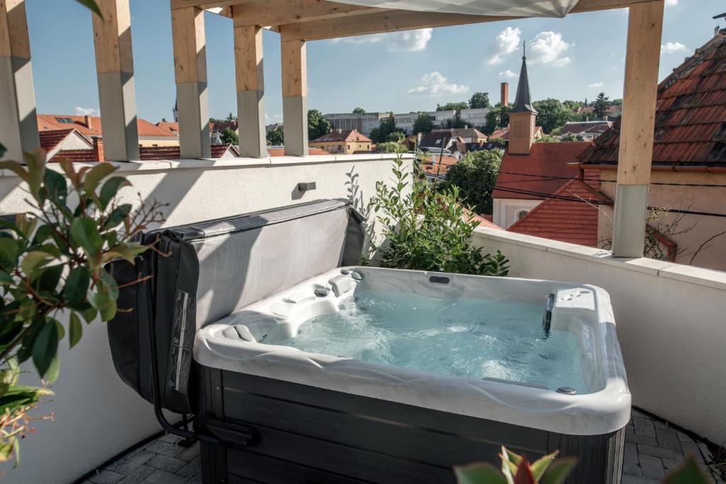 een hot tub op een balkon met uitzicht bij Loftlakásom**** in Veszprém