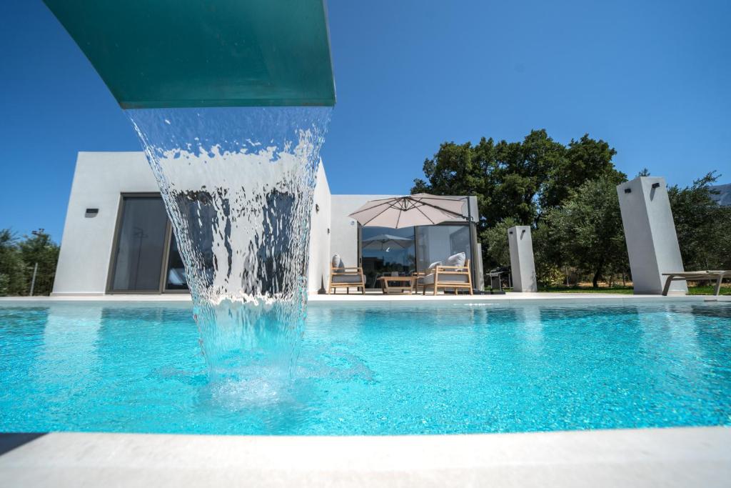 una fuente en medio de una piscina en Villa Vivian Heated Private Swimming Pool & Jacuzzi, en Georgioupolis