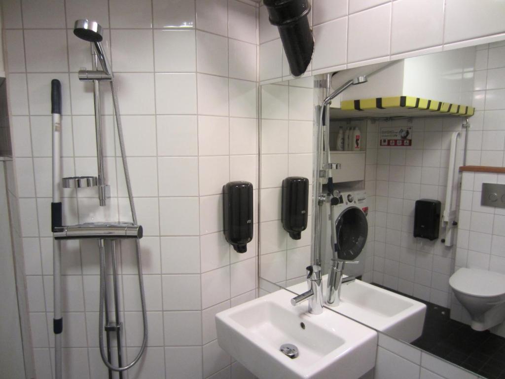 a bathroom with a sink and a phone on the wall at Hostel Dalagatan in Stockholm