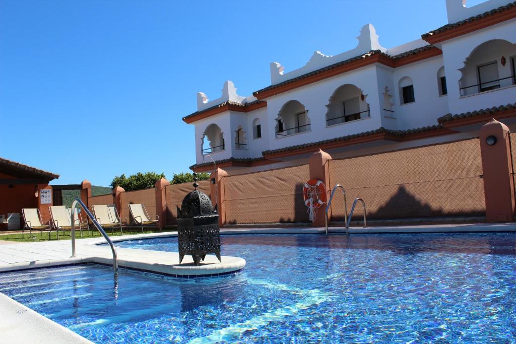 a swimming pool in front of a building at Hostal Alhambra in Zahora