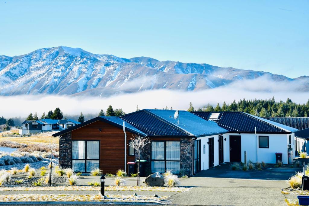 a house with mountains in the background at Stellar Apartment in Lake Tekapo