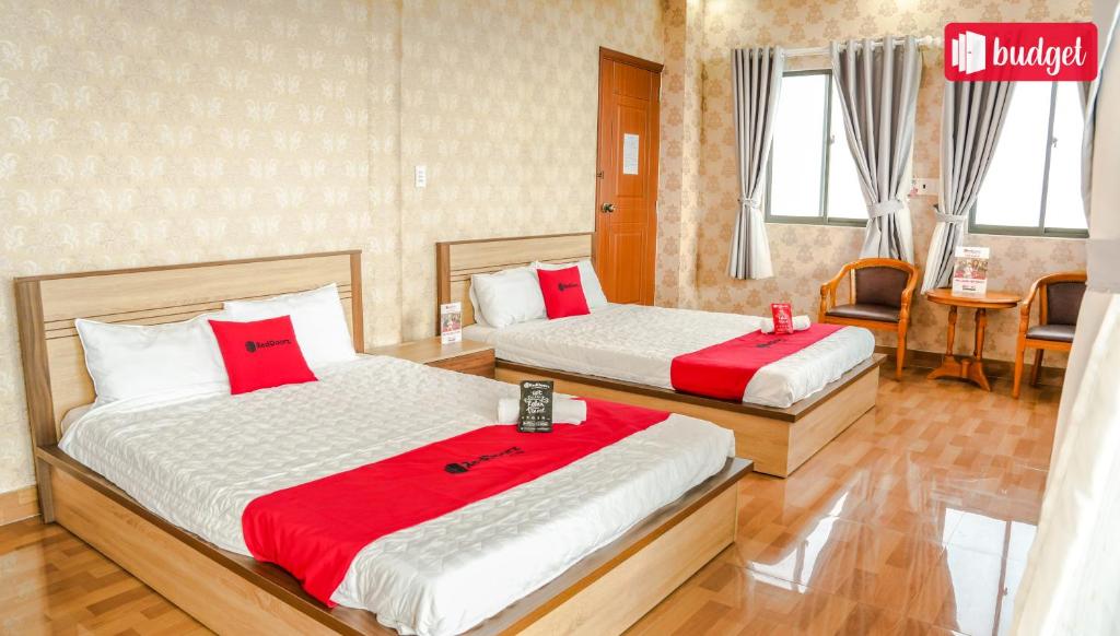 two beds in a hotel room with red pillows at Bich Thu Hotel in Ho Chi Minh City