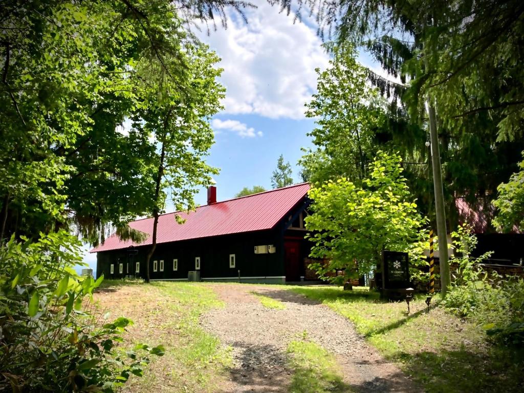 Une grande grange noire avec un toit rouge dans l'établissement N-vacation - Vacation STAY 46575v, à Biei