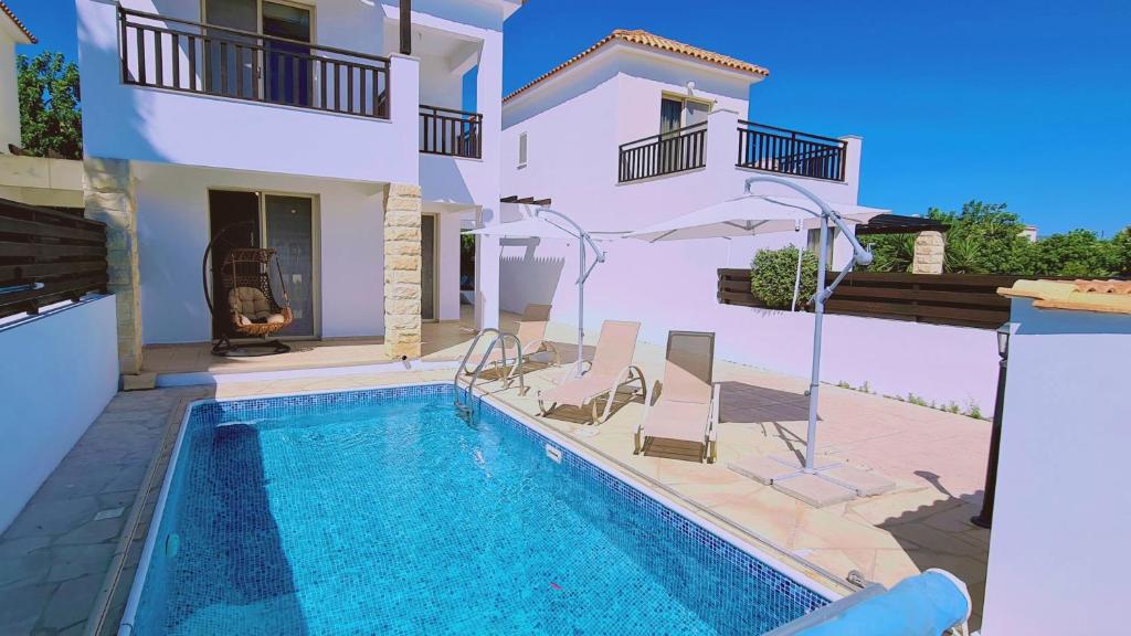 eine Villa mit Swimmingpool und ein Haus in der Unterkunft STAY Panorama - Kamelia Villa in Peyia