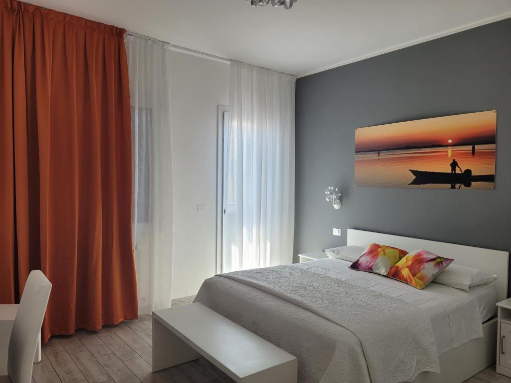 um quarto com uma cama e um quadro na parede em Casa Mara em Chioggia