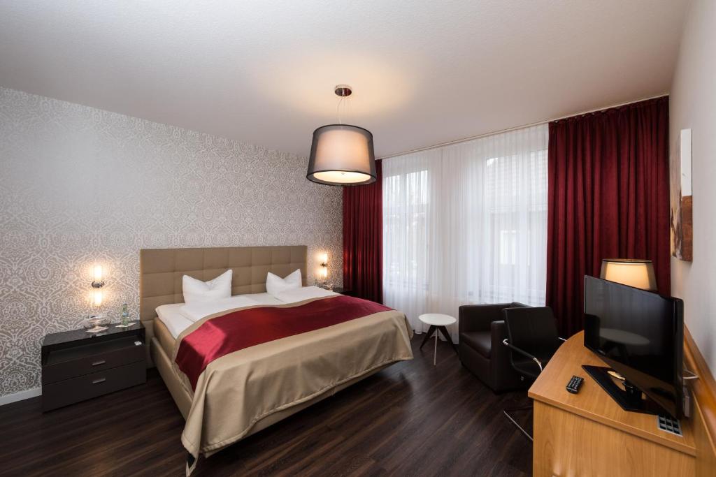 a hotel room with a bed and a television at Hotel Südlohner Hof - Ristorante Da Fabio in Südlohn