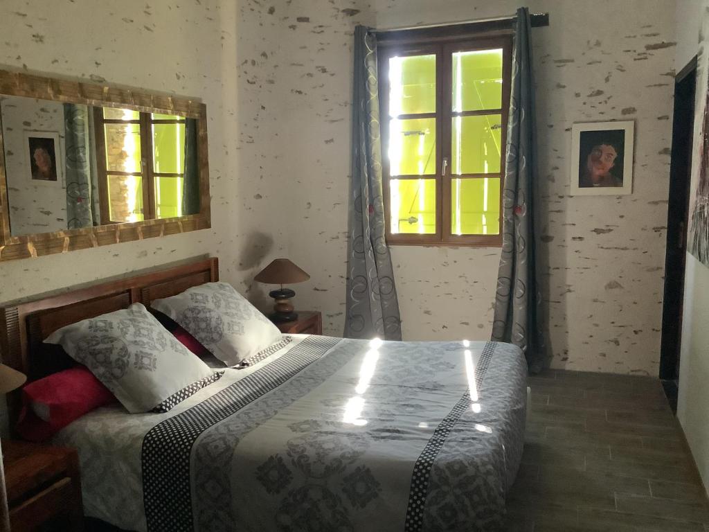 um quarto com uma cama e uma janela em Granal em Saint-Julien-Gaulène