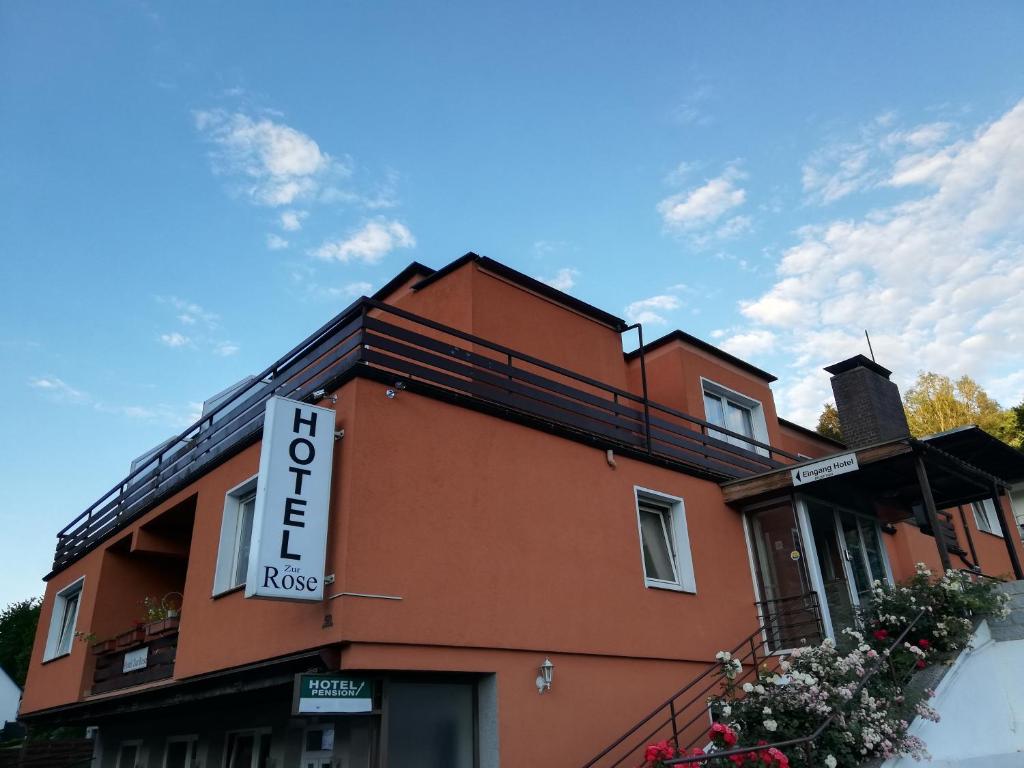 ein Gebäude mit einem Schild an der Seite in der Unterkunft Hotel Zur Rose in Bad Karlshafen