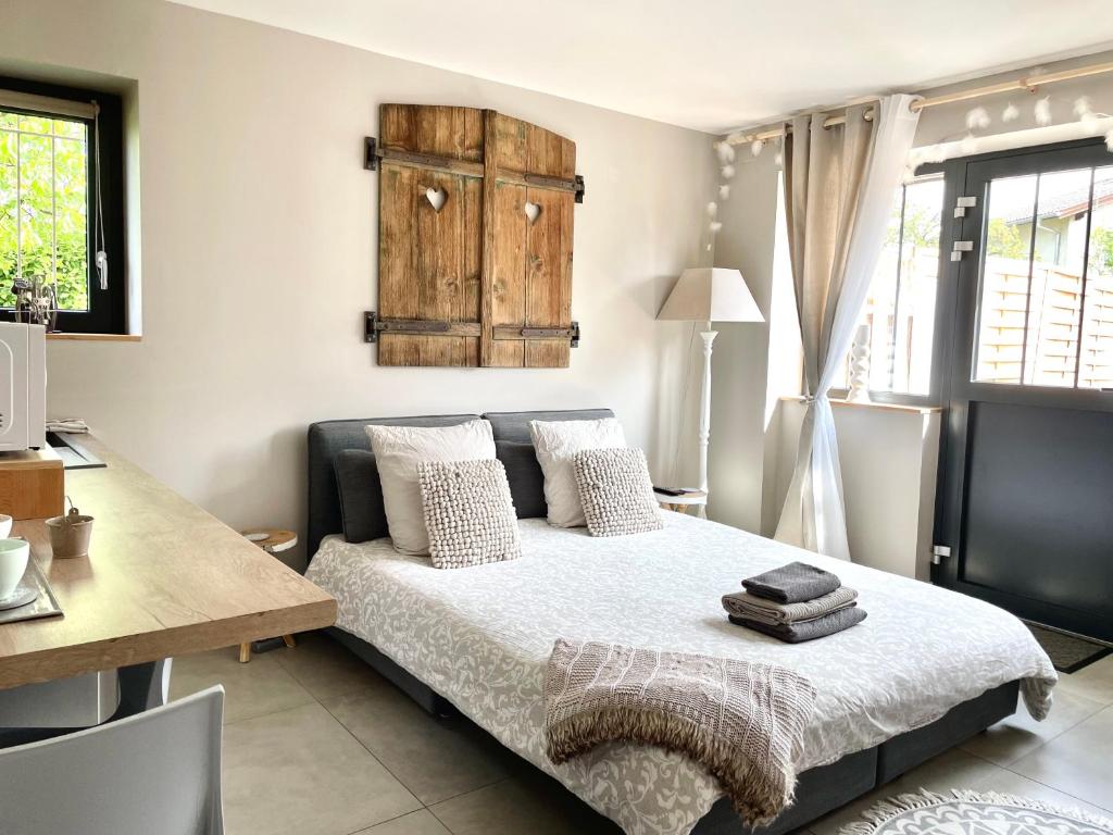 Schlafzimmer mit einem Bett mit einem Tisch und einem Schreibtisch in der Unterkunft Studio "Le Cocon" proche Colmar - Free Parking & Wifi in Horbourg