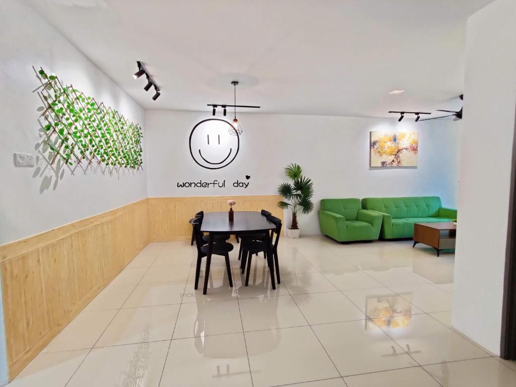 sala de estar con mesa y sofá verde en KT's Homestay- Corner Unit - Manhattan Ipoh Water Park- Station 18, en Ipoh