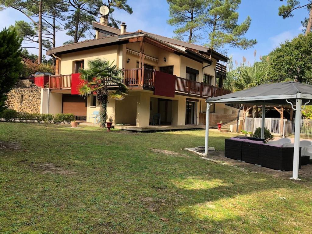 a house with an umbrella in the yard at Seignosse Villa in Seignosse