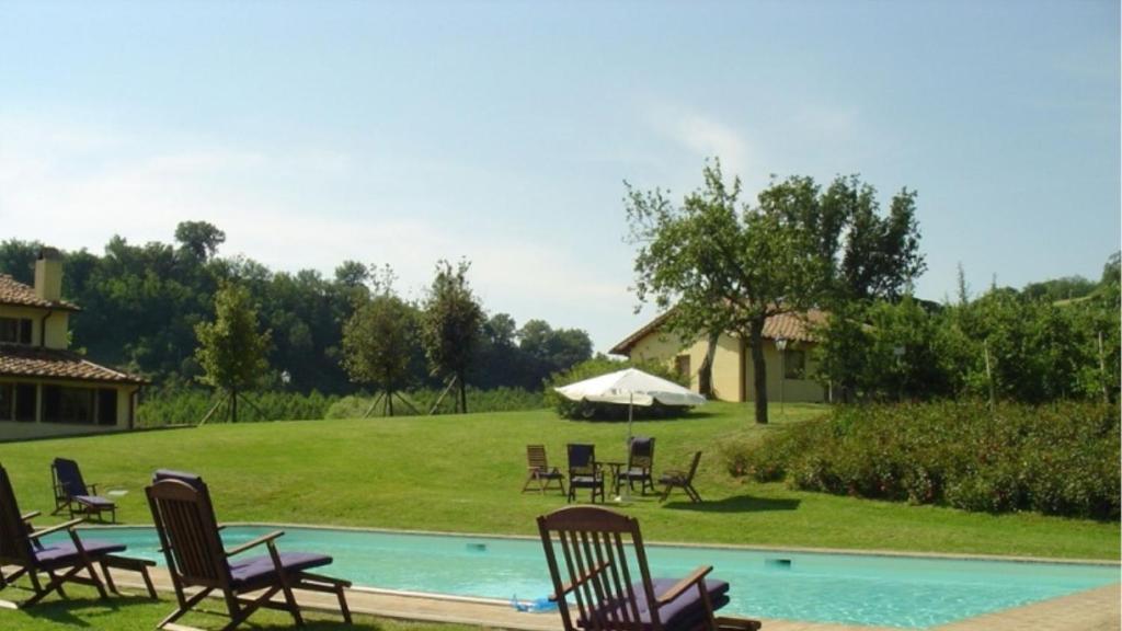 un grupo de sillas sentadas alrededor de una piscina en MAGNOLIA e CAMELIA, en Vicchio