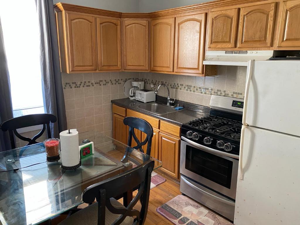a kitchen with wooden cabinets and a white refrigerator at 2cozy Apt W Fast Transportation To New York City in West New York