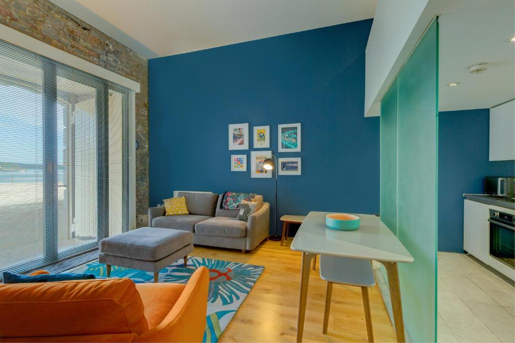 uma sala de estar azul com um sofá e uma mesa em 2 Bed- Pureserviced 5 Brewhouse em Plymouth