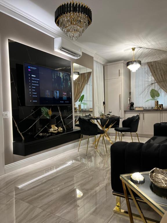 een woonkamer met een grote televisie en een tafel bij Golden Apartment in Oradea