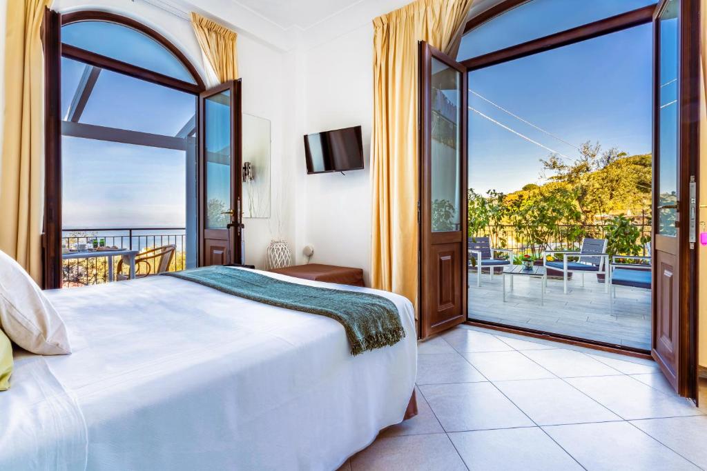 a bedroom with a large bed and a large window at Terrazza Iride in Massa Lubrense