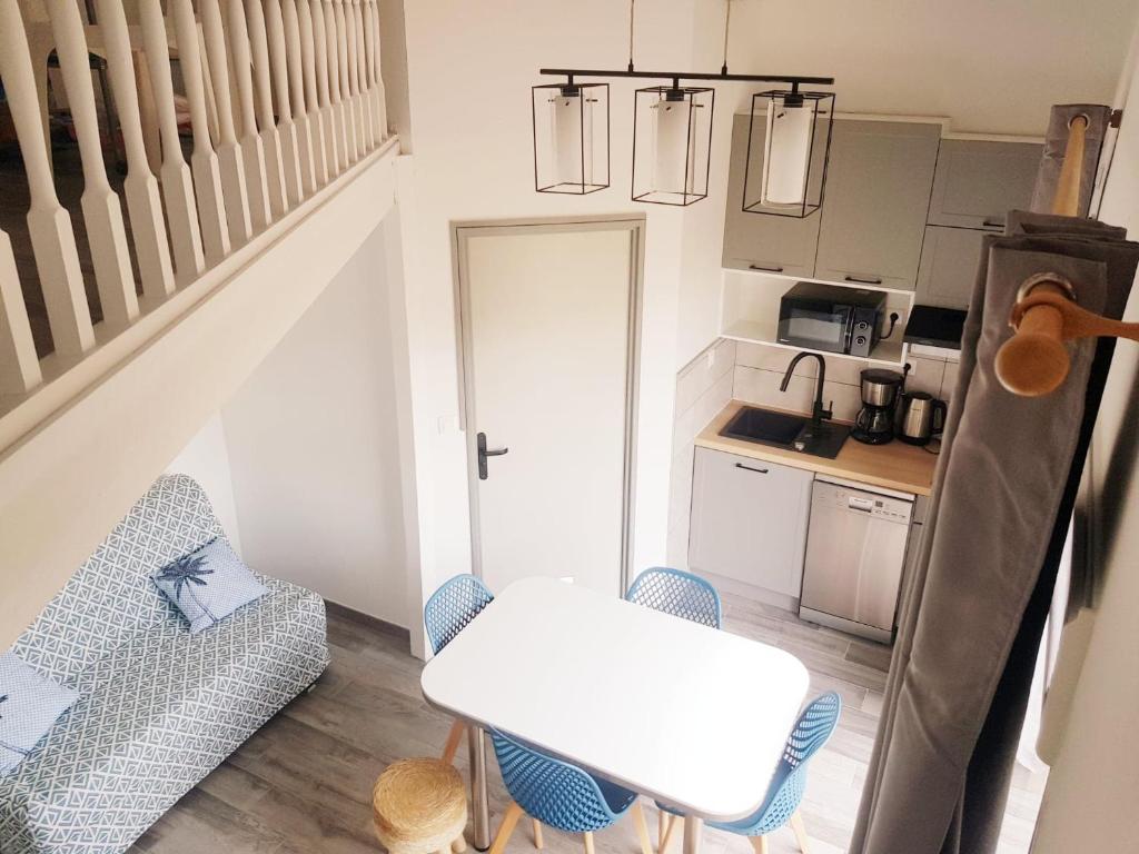 une petite cuisine avec une table et des chaises dans une pièce dans l'établissement Duplex 4-6 pers - 33m2 - 180m de la plage, à Marseillan