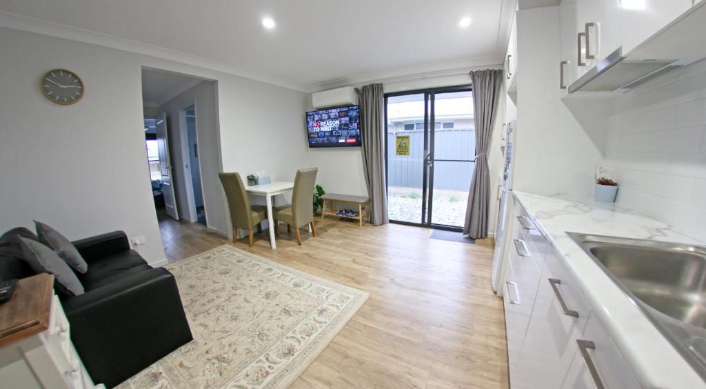 a kitchen and living room with a couch and a table at Granny Flat next to golf course in Stanthorpe