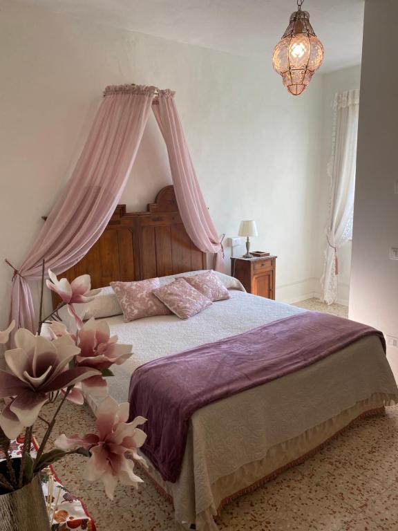 a bedroom with a large bed with a canopy at Christy House in Vignale