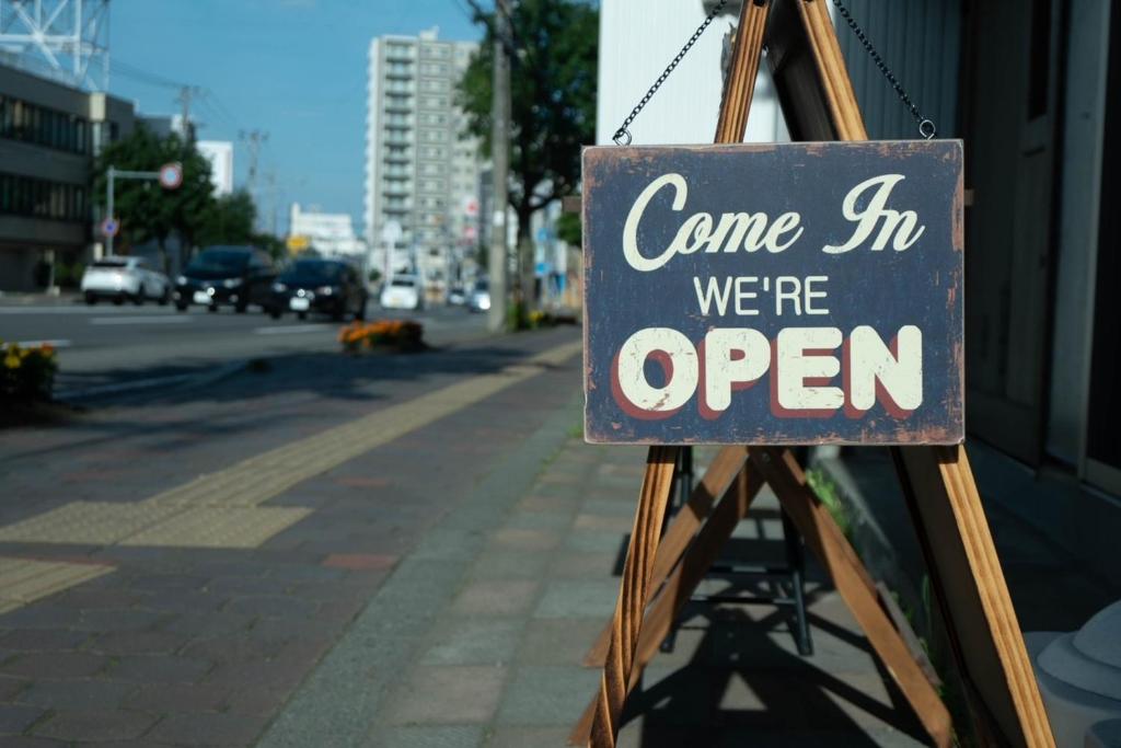 a sign that says come in we are open at Guesthouse OYADO SAPPORO in Sapporo