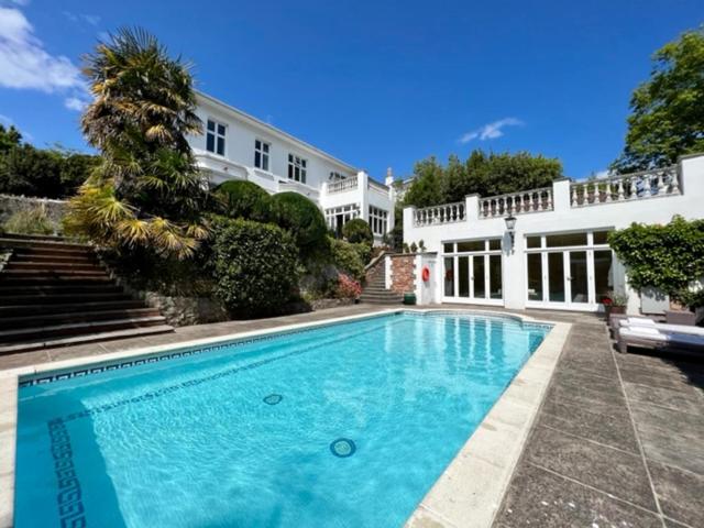a large swimming pool in front of a house at Haldon Priors in Torquay