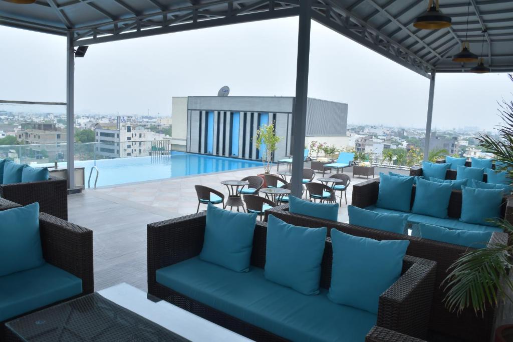 a rooftop patio with blue furniture and a pool at Cygnett Park BL in Jaipur
