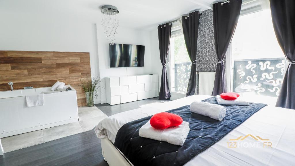123home - Suite & spa XL في مونتِفري: غرفة نوم بها سرير ووسادتين حمرا