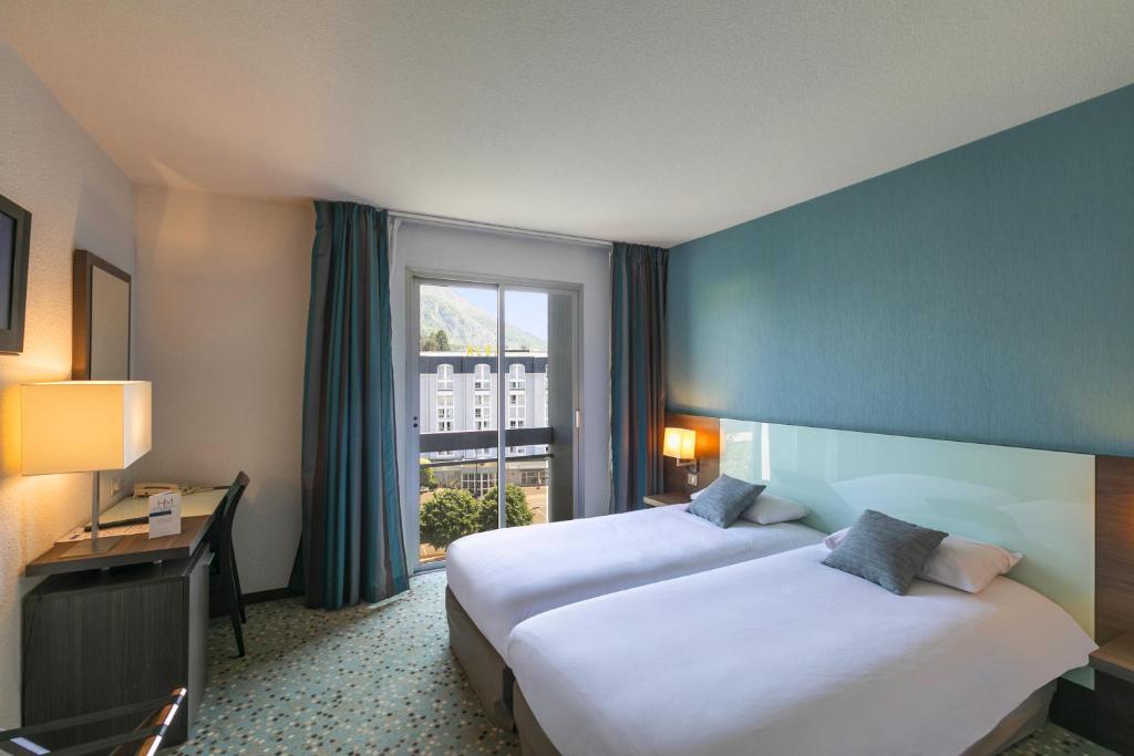 Un pat sau paturi într-o cameră la Hôtel Miramont