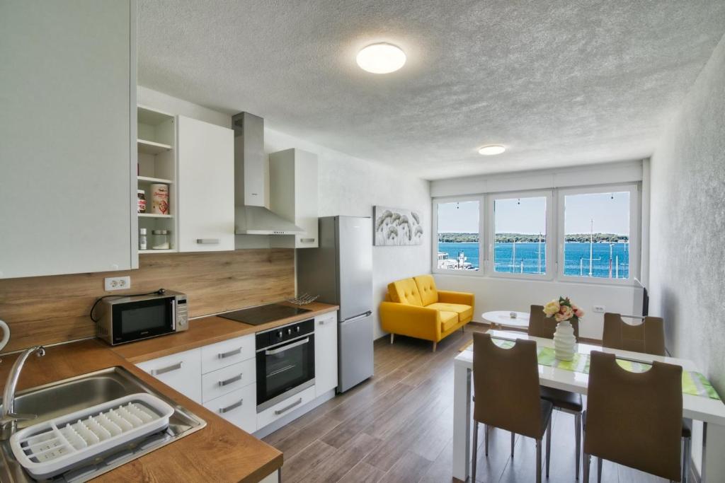 a kitchen and dining room with a table and a dining room at Apartment Marina with sea view in Pula