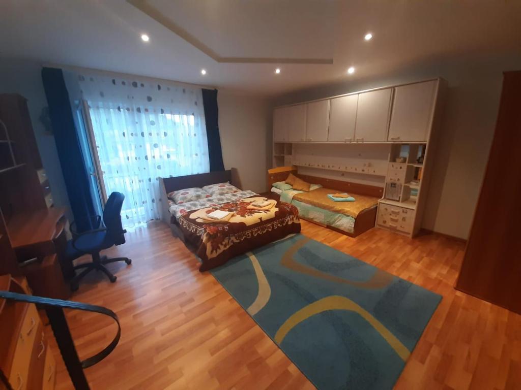 a bedroom with two beds and a table and a chair at 2Rivers in Săsciori