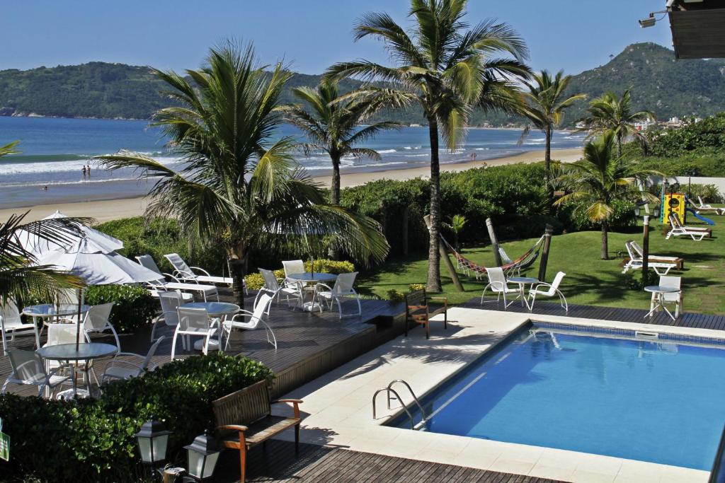 a view of a pool and the beach from a resort at Pousada Morada do Guaruça in Bombinhas