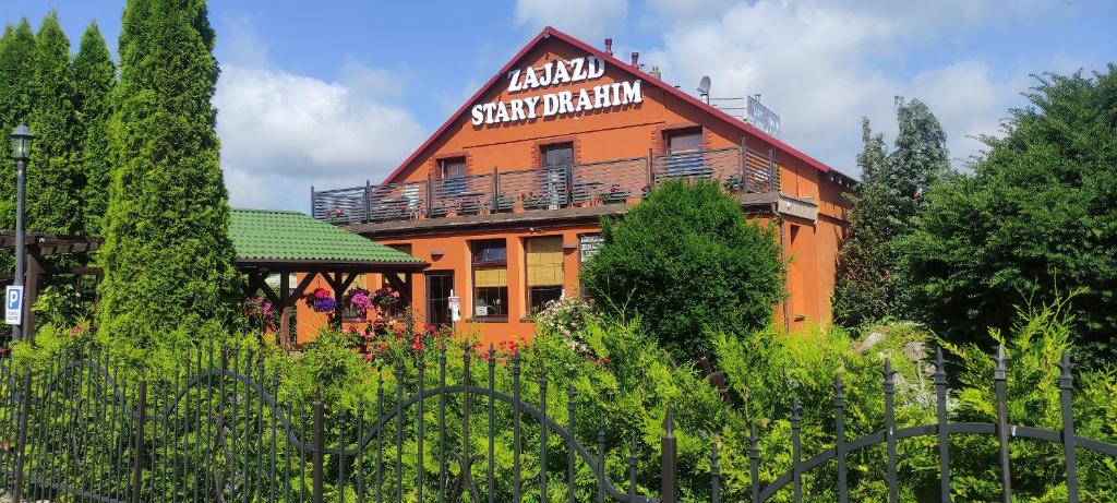 an orange building with a sign on top of it at Stary Drahim in Czaplinek