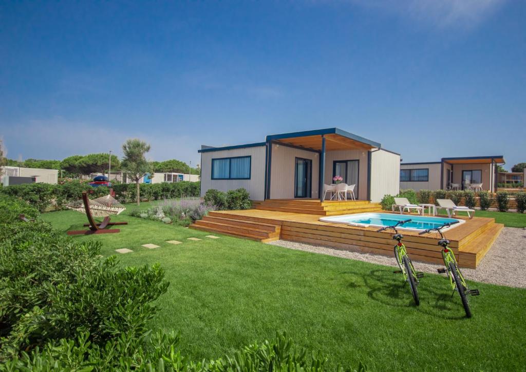 a house with a swimming pool in a yard at Arena Grand Kazela Camping Homes in Medulin